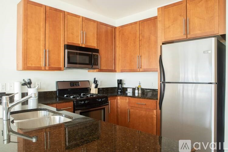 A kitchen with wooden cabinets and a stainless steel refrigerator.