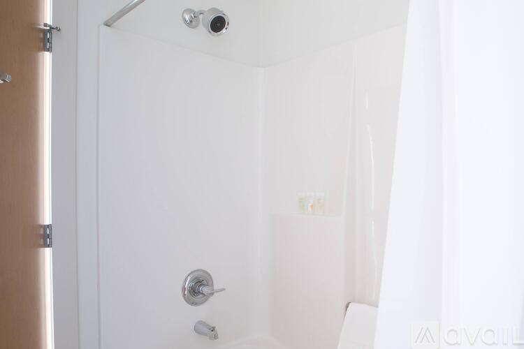 A white bathroom with a shower curtain and a door.