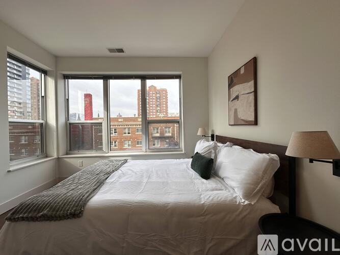 A bedroom with a large bed and a view of the city.