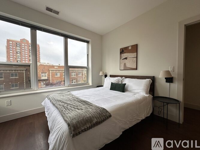 A bedroom with a large bed and a view of the city.