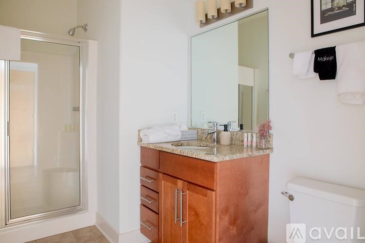 A bathroom with a marble countertop and a glass-enclosed shower.