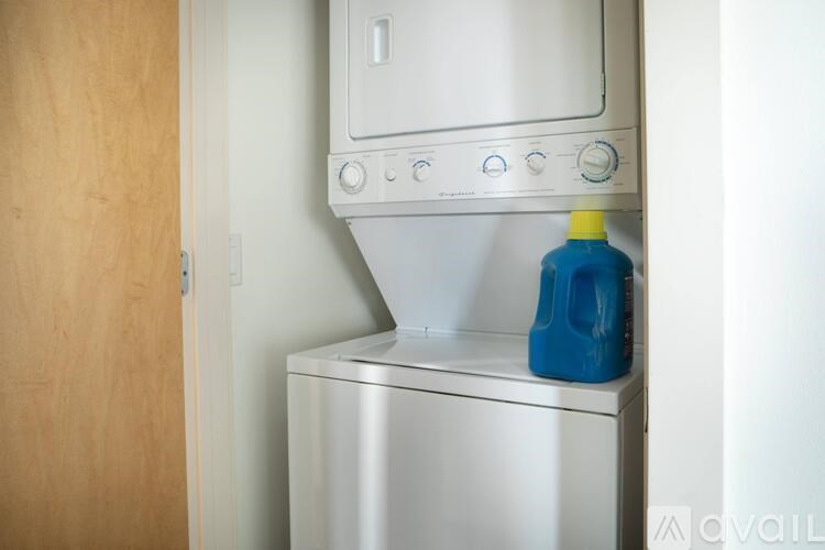 A blue bottle is on top of a silver dishwasher.