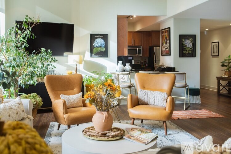 A living room with two chairs, a table, and a television.