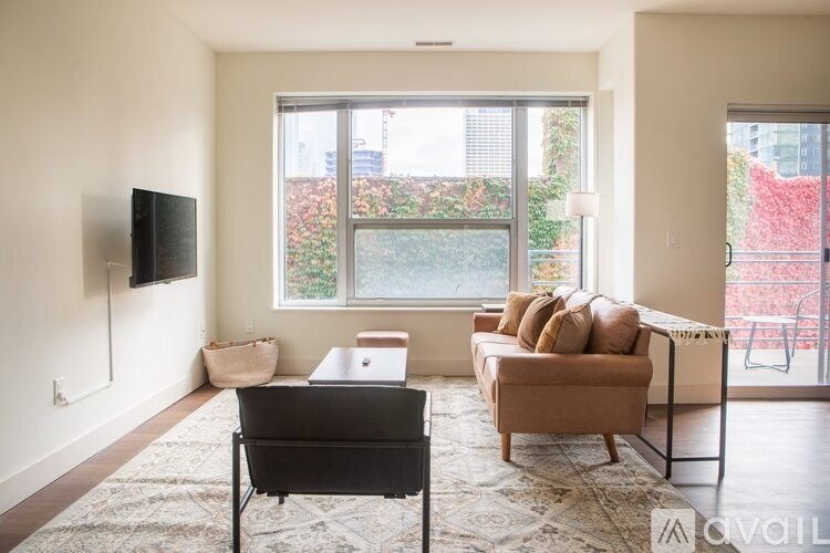 A living room with a couch, chair, and television.