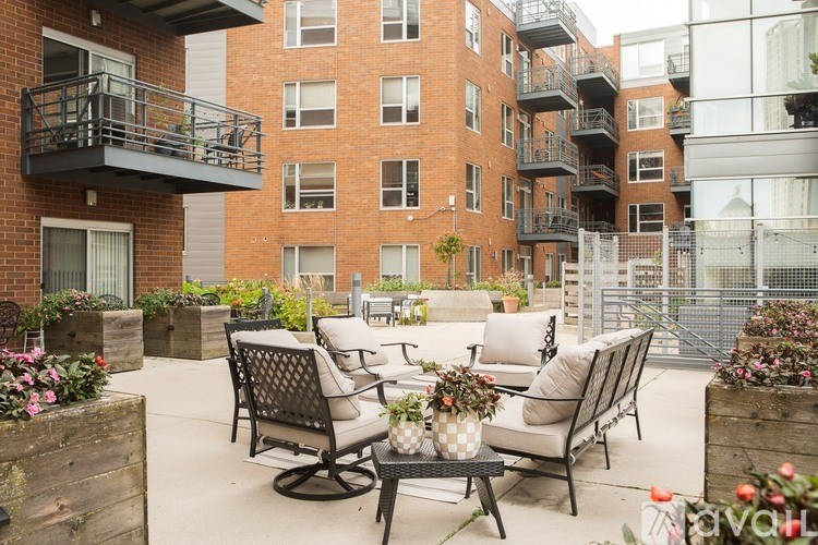 A patio with a table and chairs is surrounded by a brick building.