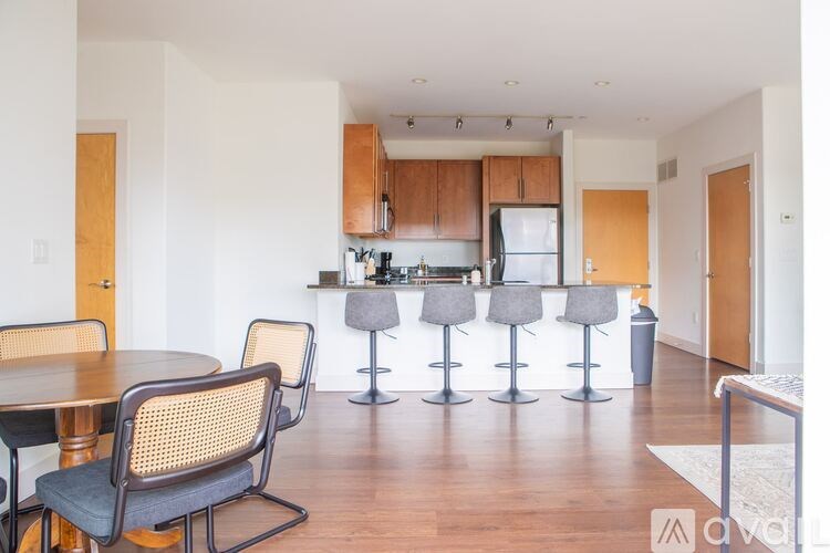 A kitchen with a table and chairs in the foreground and a bar area in the background.