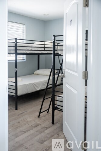 A bunk bed in a room with a white door.