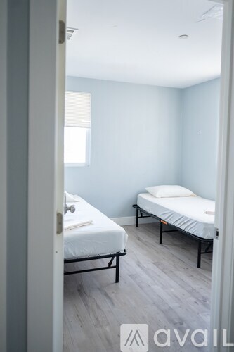 A bedroom with two beds and a window.
