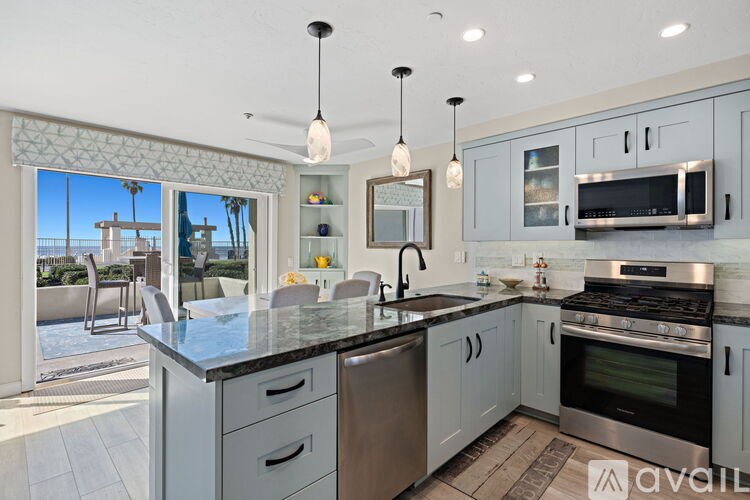 A kitchen with a large island and stainless steel appliances.