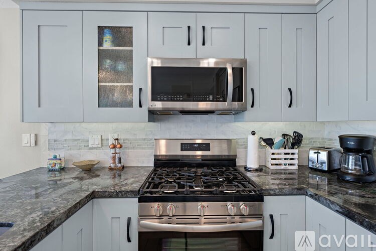 A modern kitchen with a stove top oven and microwave above it.
