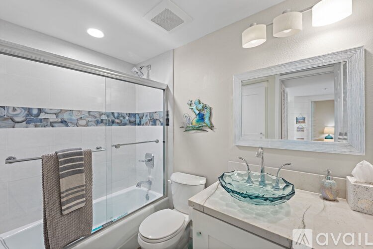 A bathroom with a toilet, sink, and shower.