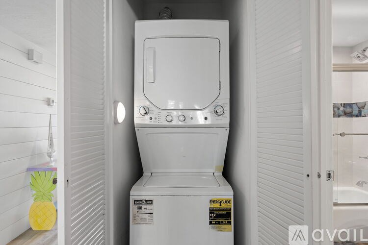 A white tankless water heater with a yellow pineapple decoration on the wall.