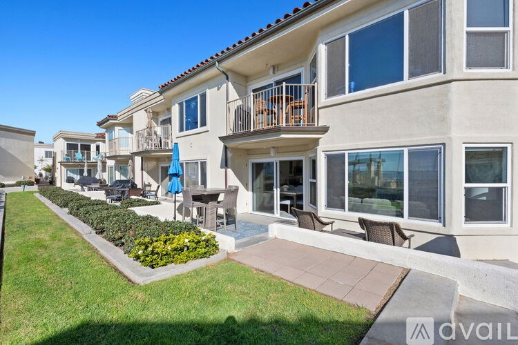 A row of modern townhouses with balconies and outdoor seating areas.
