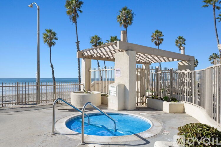 A pool area with a fence and palm trees.