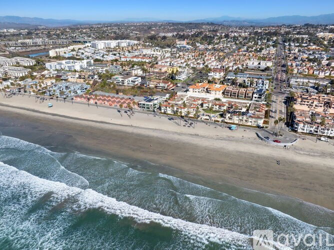 A beachfront city with a sandy beach and waves crashing in.