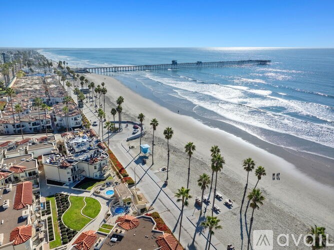 A beachfront community with a pier in the distance.