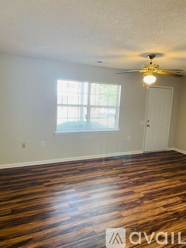 A room with a ceiling fan and a door.