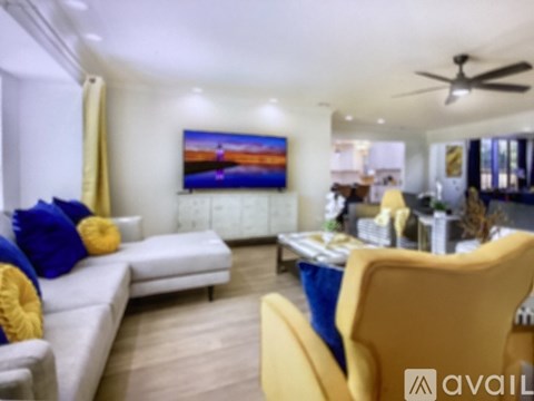 A living room with a white couch and yellow chairs.