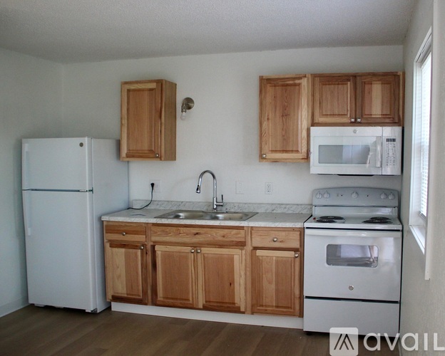 A kitchen with white appliances and wooden cabinets.
