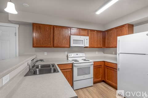 A kitchen with wooden cabinets and white appliances.