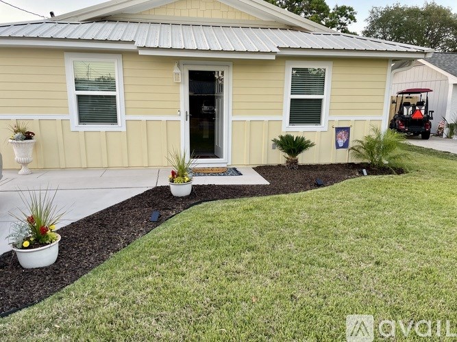 A yellow house with a red golf cart in the background.