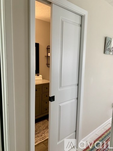 A white door is open to a bathroom.
