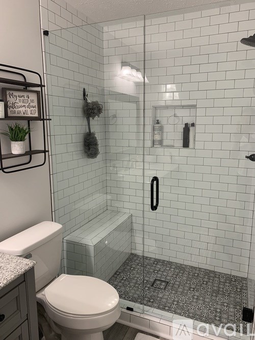 A white toilet sits next to a glass shower door in a bathroom.