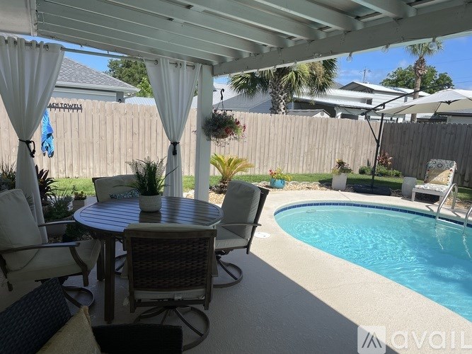 A patio with a table and chairs under a white canopy.