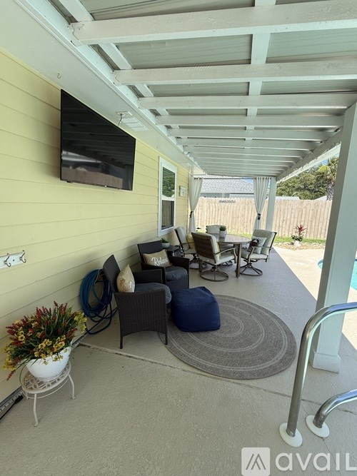 A patio with a white table and chairs under a roof.