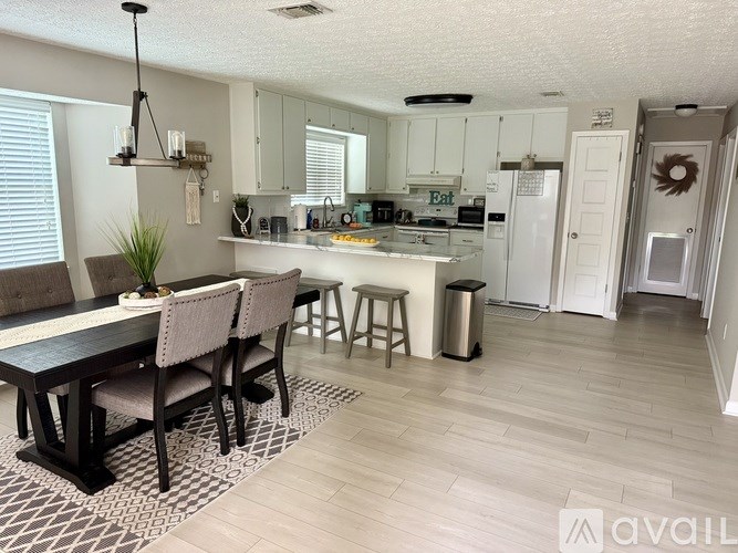 A kitchen with a dining table and chairs.
