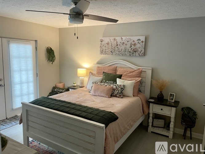 A bedroom with a large bed and a ceiling fan.
