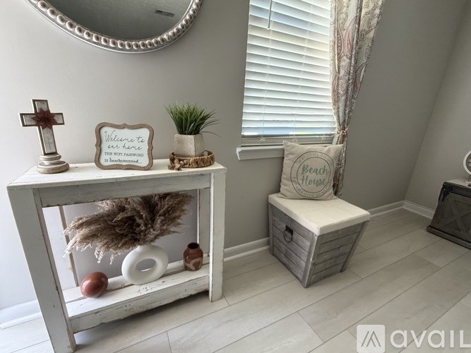 A bathroom with a white toilet and a white cabinet with a mirror above it.
