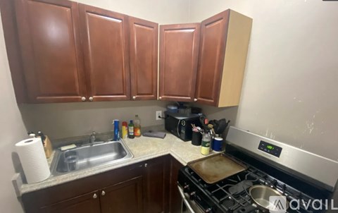 A kitchen with brown cabinets and a stove top oven.