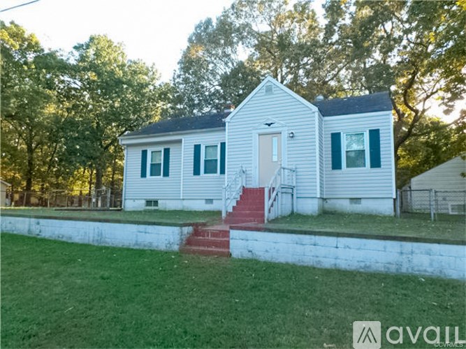 A small white house with a red staircase leading to the front door.