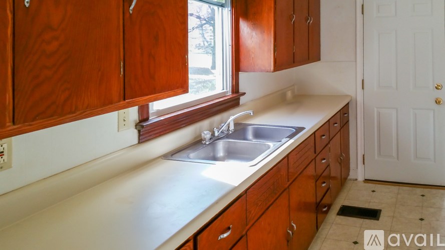 A kitchen with wooden cabinets and a white sink.