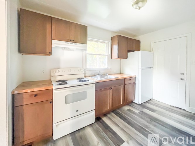 A kitchen with white appliances and wooden cabinets.