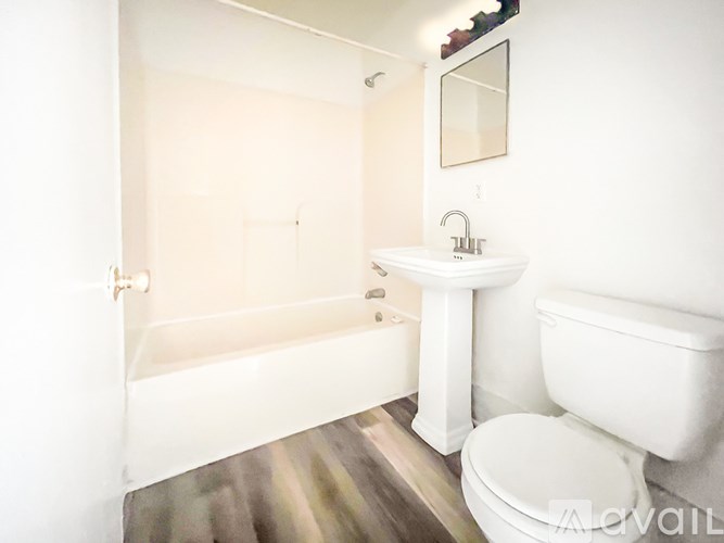 A white bathroom with a tub, toilet, and sink.