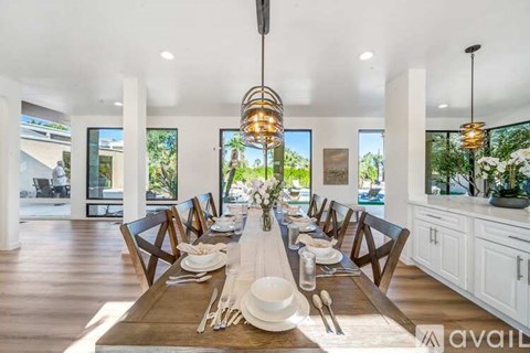 A dining room with a long table set for a meal.