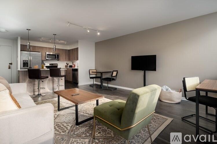 A living room with a white couch, a green chair, and a television.