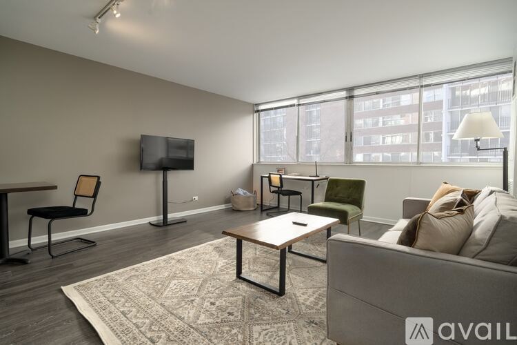 A living room with a grey couch, a wooden coffee table, and a television.
