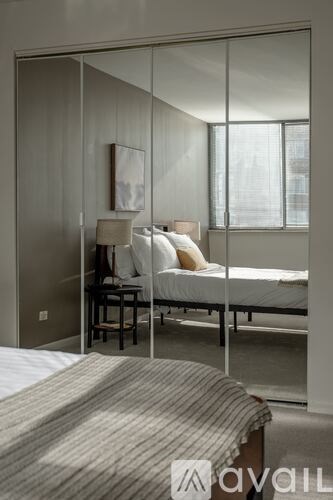 A bedroom with a bed, nightstand, and chair.