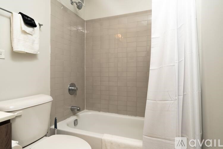 A white toilet sits next to a white bathtub in a bathroom.