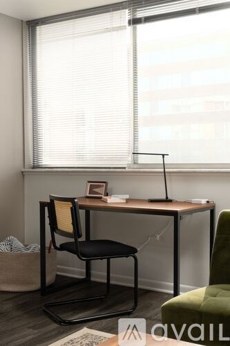 A black chair sits in front of a desk with a laptop on it.