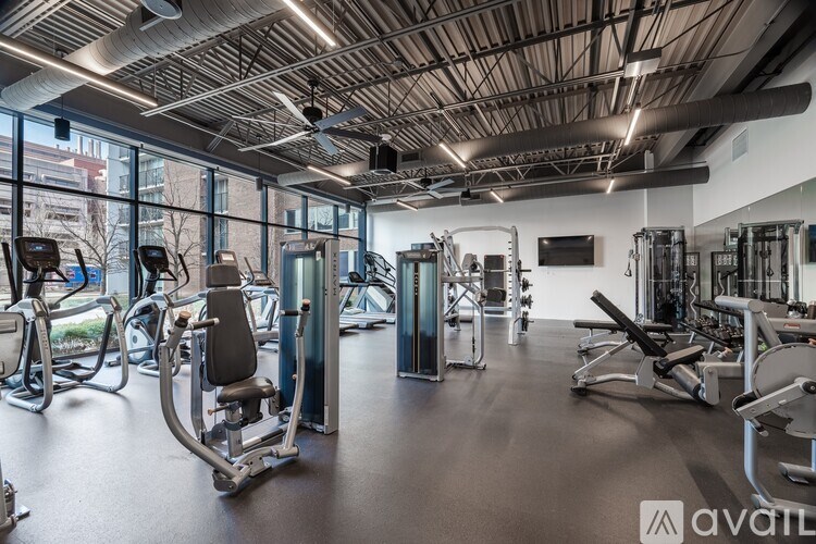 A gym with a variety of equipment including treadmills, weights, and exercise machines.
