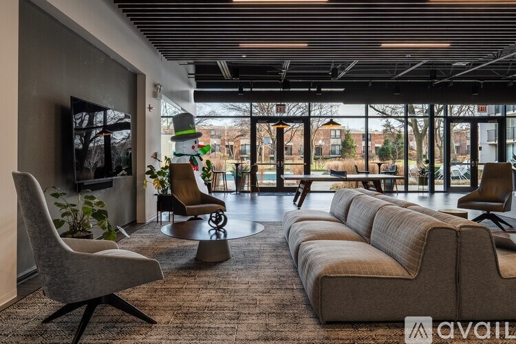 A living room with a grey sofa, a grey chair and a television.