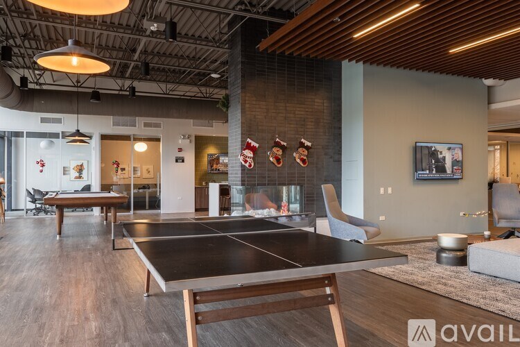 A ping pong table is in the middle of a room with a wooden floor.