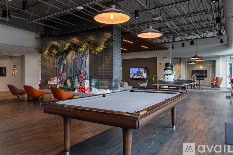 A pool table is in the middle of a room with a TV and Christmas decorations.
