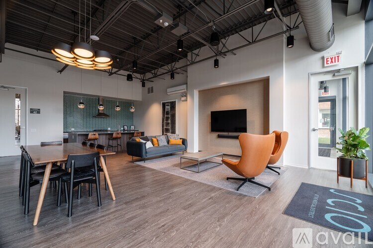 A modern office space with a wooden floor and a large orange chair.