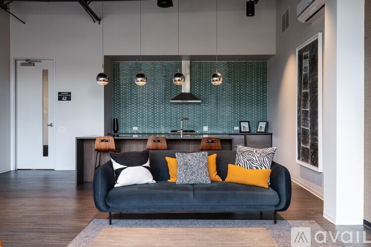 A modern living room with a black couch and a green patterned backsplash.