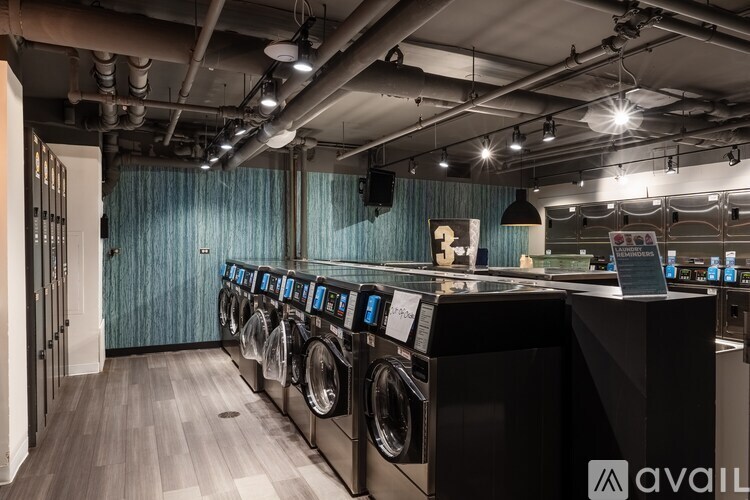 A row of washing machines are lined up in a laundromat.
